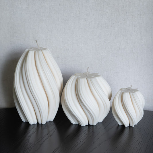 3er Kerzen Set Bøluna in natürlichem Cremeton – skulpturale Designkerzen, Rapswachs, handgefertigt in Hamburg, 100 % pflanzlich & nachhaltig. Studio Z. Stumpenkerzen in Wellenform, geschwungen und bauchig. Dekoriert auf schwarzem Tisch.