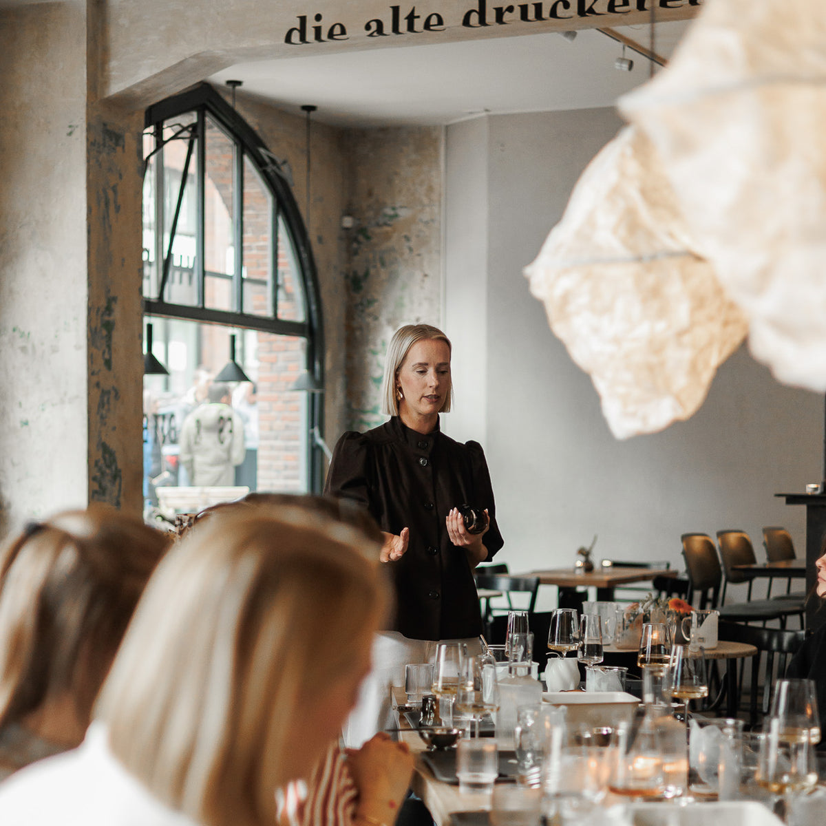 Gründerin erklärt ablauf bei kerzenworkshop in weinbar in hamburg manufaktur Z