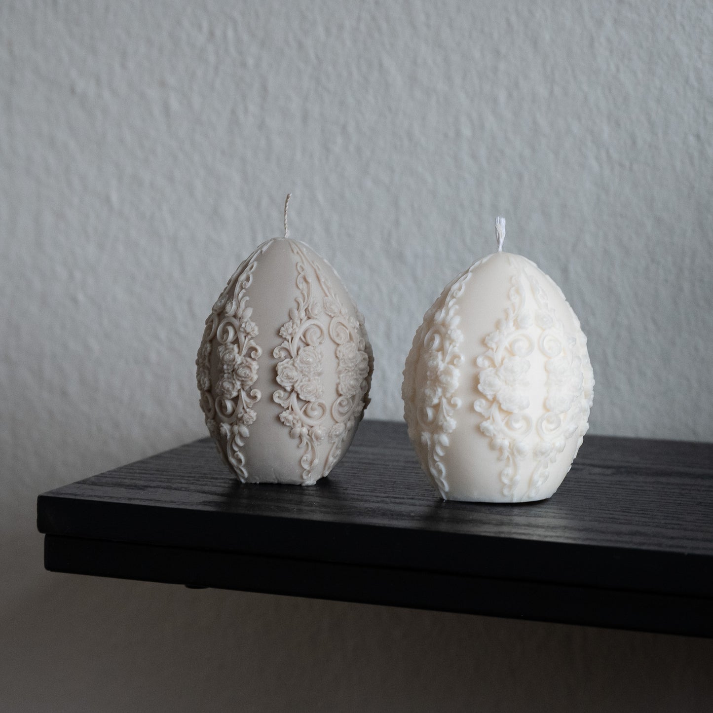Osterei Kerze Faberge Ei Geschenk Ostern verziert neben Vase zwei Osterei Kerzen mit Blüten Schnitzereien aus Tisch