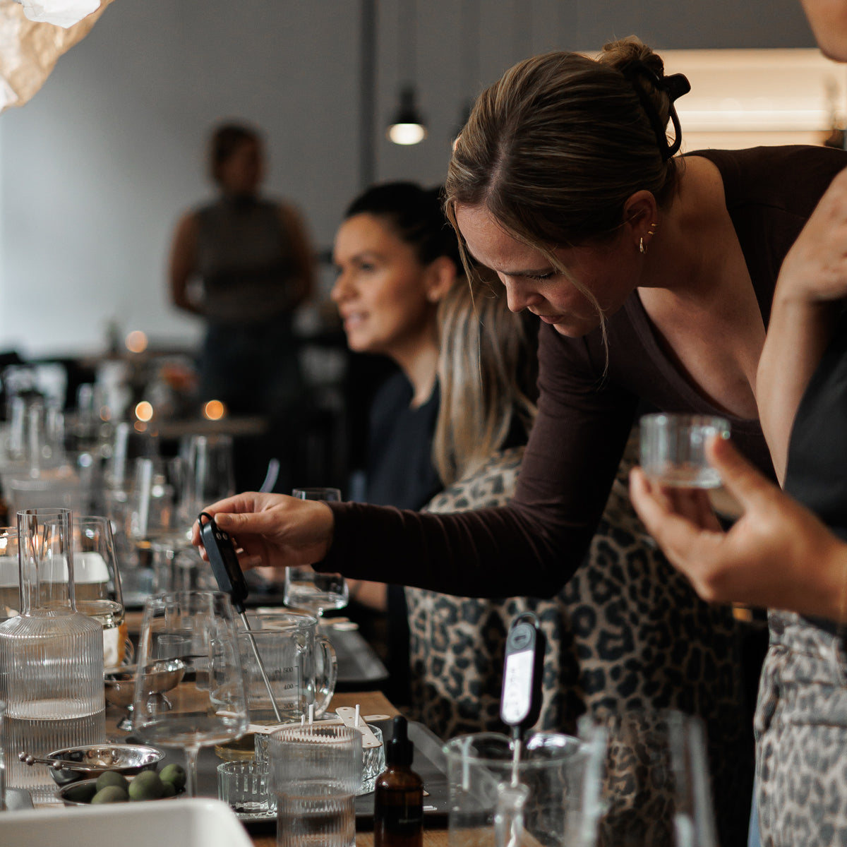 Teilnehmende bei Kreativem Kerzenworkshop mit Wachs, Duft, Cremant und Snacks in einer stilvollen Weinbar.