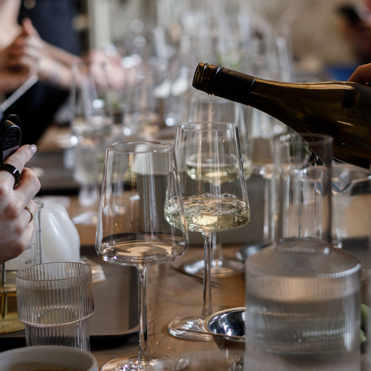tisch mit wein und wachs und kerzen gießen teilnehmerinnen event workshop cremant